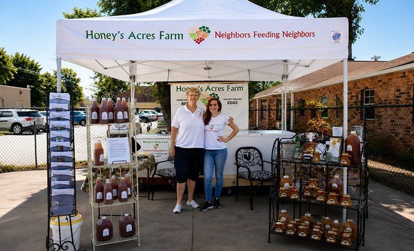 Vendor canopy displaying local products at an outdoor farmers market